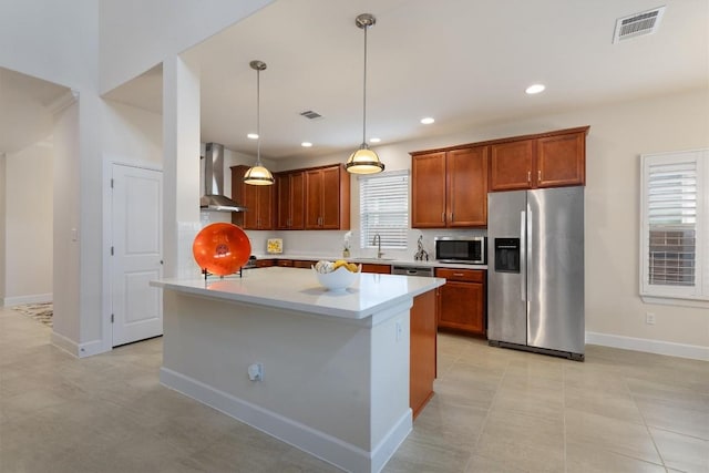 kitchen featuring light tile patterned flooring, wall chimney exhaust hood, sink, pendant lighting, and stainless steel appliances