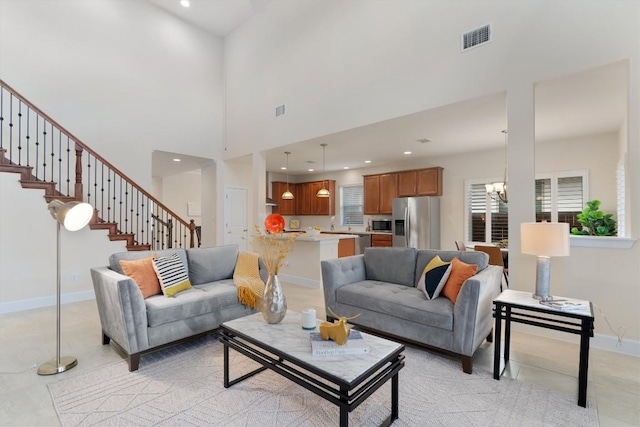 living room with a towering ceiling and a chandelier