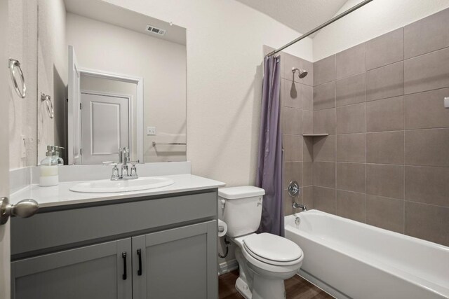 full bathroom featuring vanity, hardwood / wood-style floors, shower / bath combo, and toilet