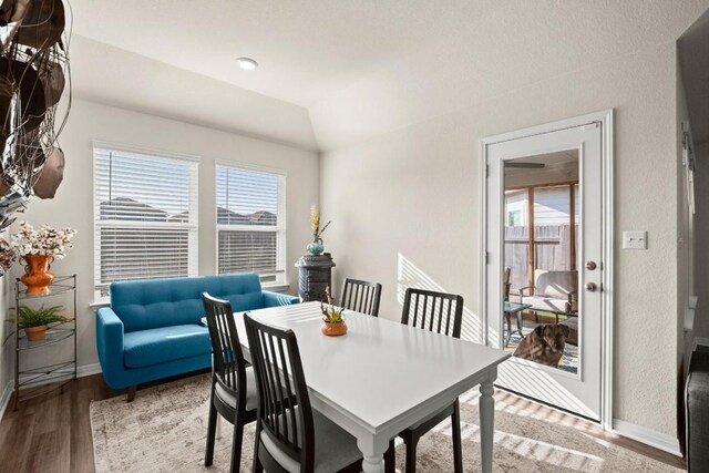 dining room featuring light hardwood / wood-style floors and vaulted ceiling