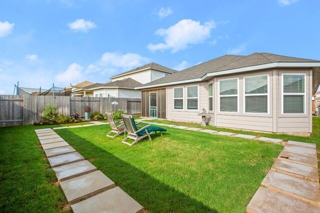 rear view of property featuring a lawn