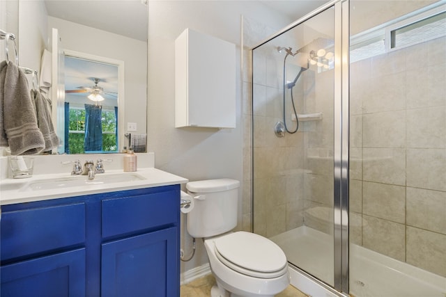 bathroom featuring walk in shower, toilet, vanity, and ceiling fan