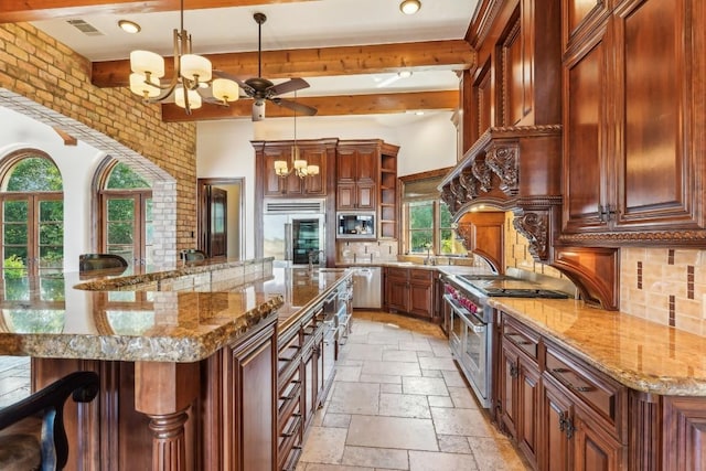 kitchen with hanging light fixtures, a notable chandelier, stone tile floors, and a large island