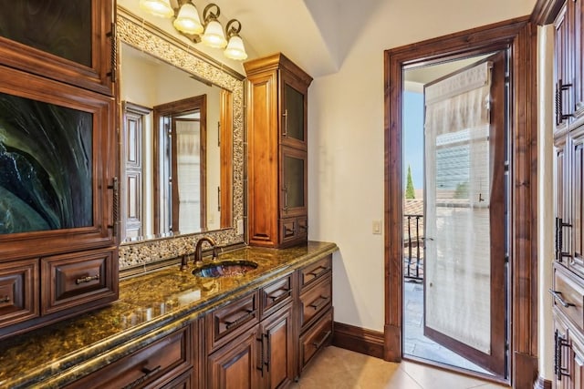 bathroom with baseboards, vanity, and tile patterned flooring