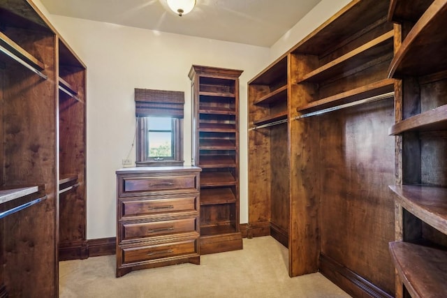 walk in closet featuring light carpet