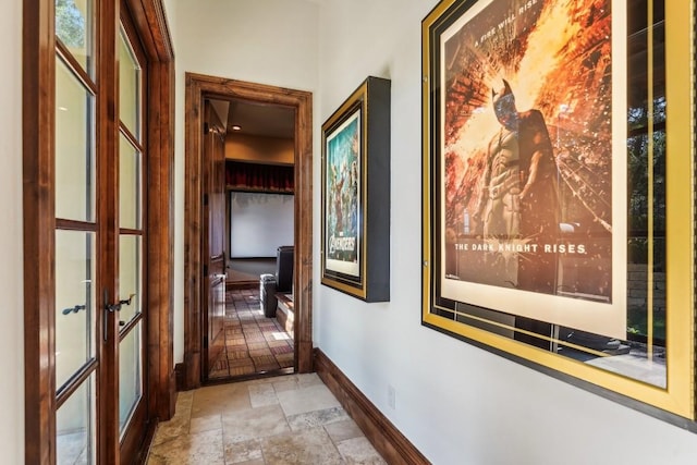 hall featuring baseboards, french doors, and stone tile floors