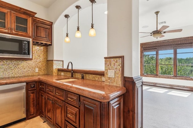 kitchen with a sink, fridge, built in microwave, tasteful backsplash, and glass insert cabinets