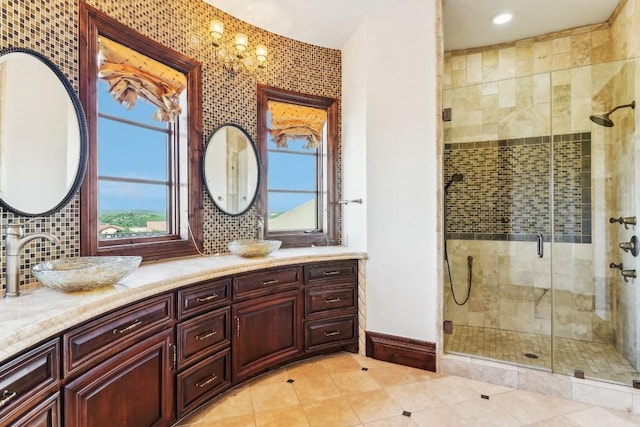 226 Canyon Turn Trl, Austin, TX 78734 - bathroom featuring baseboards, double vanity, a stall shower, tile patterned floors, and decorative backsplash