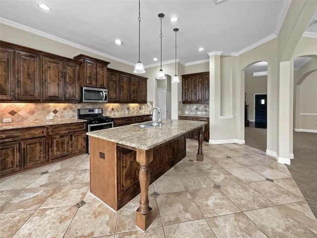 kitchen with light stone counters, a center island with sink, appliances with stainless steel finishes, a kitchen breakfast bar, and pendant lighting