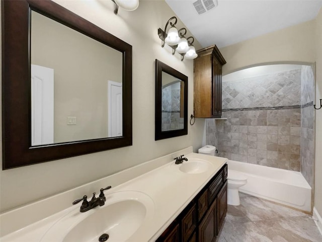 full bathroom with tiled shower / bath combo, vanity, and toilet