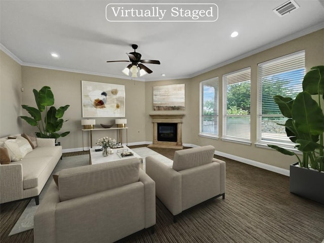 living room with dark colored carpet, crown molding, ceiling fan, and a high end fireplace