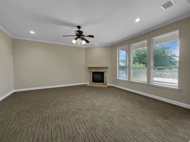 unfurnished living room with dark colored carpet, ornamental molding, and ceiling fan