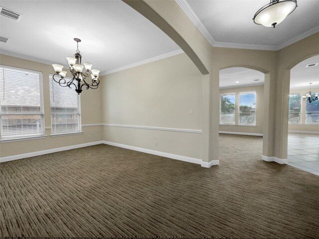 unfurnished room featuring a notable chandelier, ornamental molding, and dark colored carpet