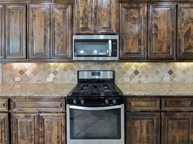 kitchen featuring light stone countertops, appliances with stainless steel finishes, backsplash, and dark brown cabinetry