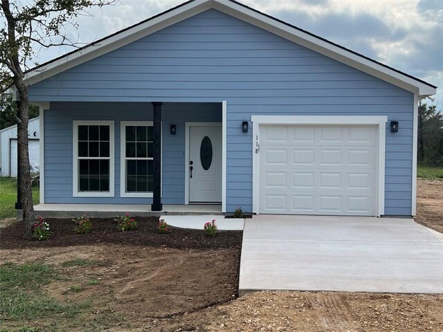 view of front of home featuring a garage and an outbuilding