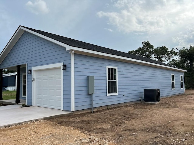 view of property exterior with a garage and cooling unit