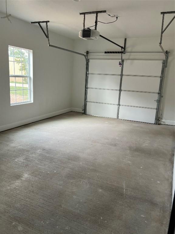 garage with a garage door opener and baseboards