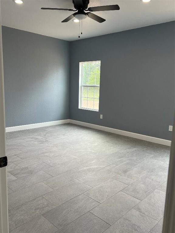 empty room featuring light tile patterned floors and ceiling fan