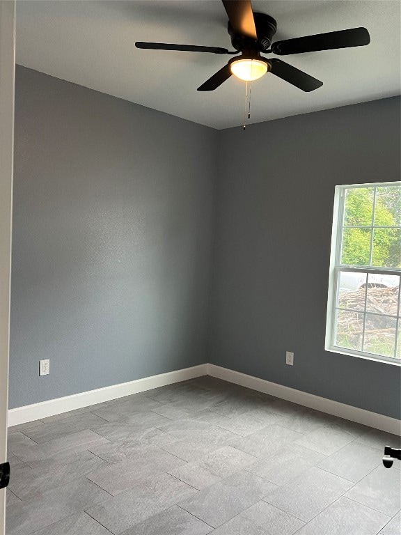 empty room with light tile patterned flooring and ceiling fan