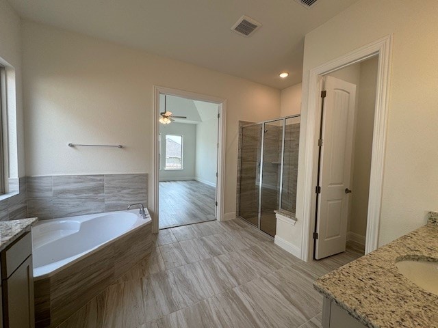 bathroom featuring vanity, ceiling fan, and plus walk in shower