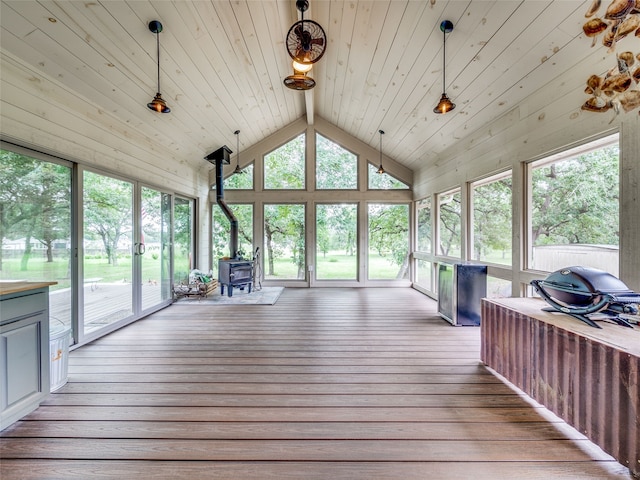 unfurnished sunroom with wood ceiling, vaulted ceiling, and a wood stove