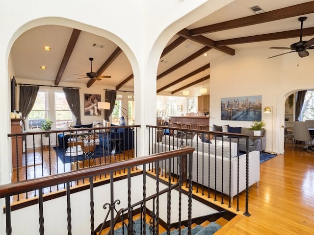 hallway featuring vaulted ceiling with beams and light hardwood / wood-style flooring