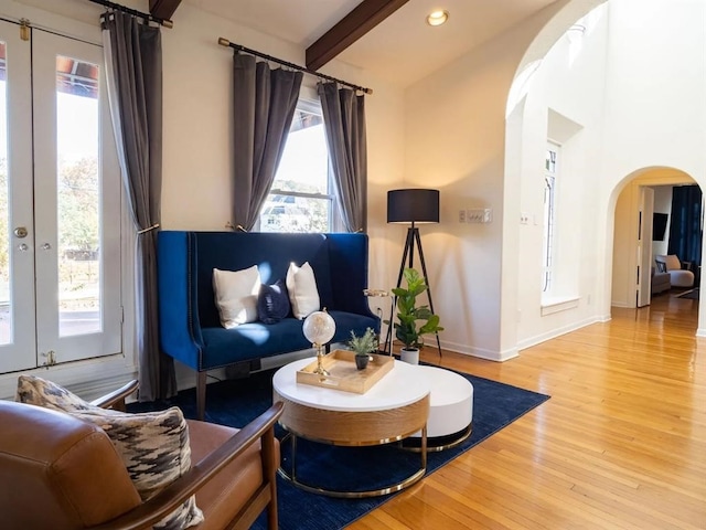 sitting room with beam ceiling, french doors, and light hardwood / wood-style flooring