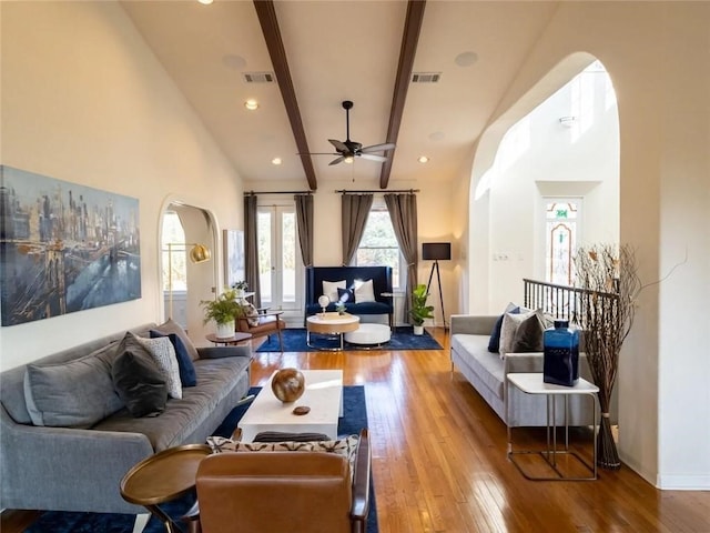 living room featuring beam ceiling, hardwood / wood-style flooring, high vaulted ceiling, and ceiling fan