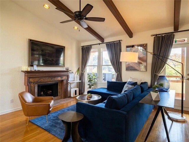 living room featuring hardwood / wood-style flooring, vaulted ceiling with beams, and ceiling fan