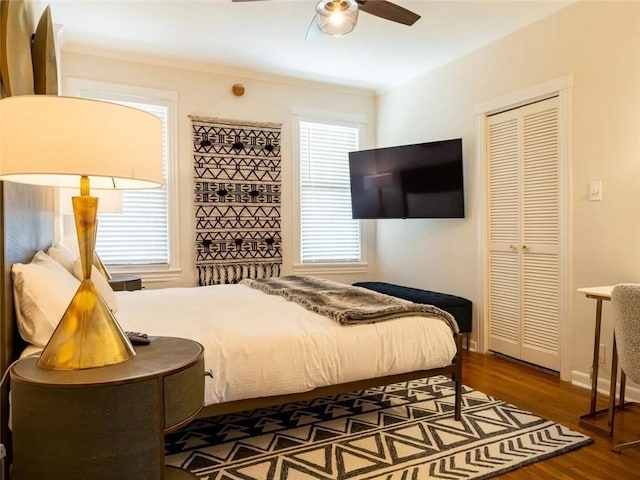 bedroom with dark hardwood / wood-style flooring, a closet, and ceiling fan