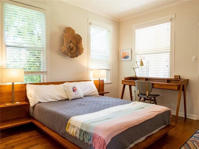 bedroom with ornamental molding and hardwood / wood-style floors