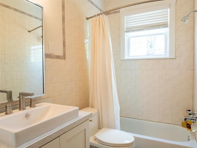 full bathroom featuring shower / tub combo, tile walls, toilet, and vanity