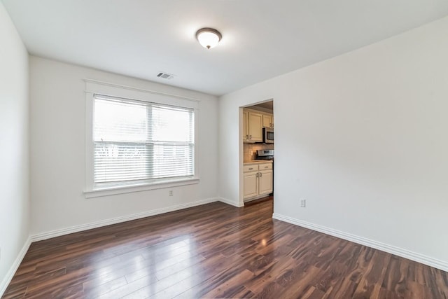 spare room with dark hardwood / wood-style floors