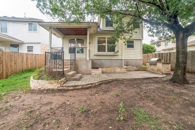 back of property with area for grilling and a patio