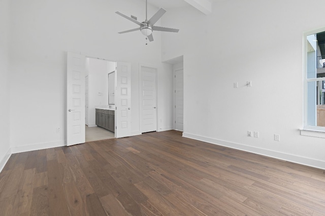 unfurnished bedroom with ensuite bath, ceiling fan, hardwood / wood-style flooring, and high vaulted ceiling