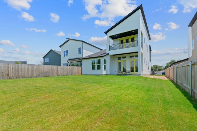 rear view of house featuring a balcony, a lawn, and a patio area