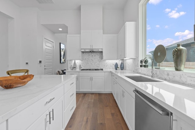 kitchen with white cabinets, dark hardwood / wood-style floors, appliances with stainless steel finishes, decorative backsplash, and sink