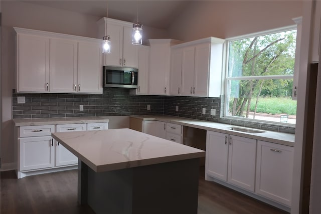 kitchen featuring white cabinets, a kitchen island, and a wealth of natural light