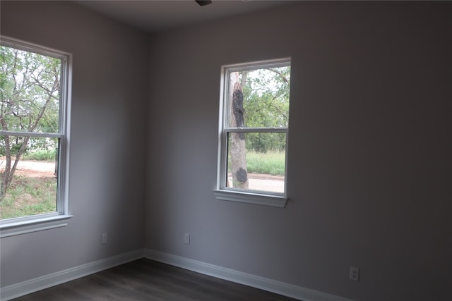 empty room featuring dark hardwood / wood-style floors and plenty of natural light