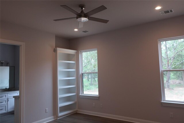 unfurnished room featuring ceiling fan, dark hardwood / wood-style floors, and plenty of natural light