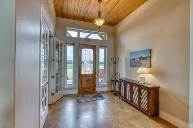 foyer featuring concrete floors, french doors, and wood ceiling