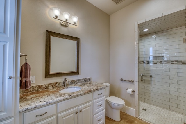 bathroom featuring a shower with door, vanity, and toilet