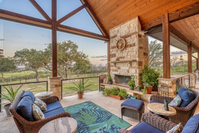 sunroom / solarium with an outdoor stone fireplace, a wealth of natural light, lofted ceiling, and wood ceiling