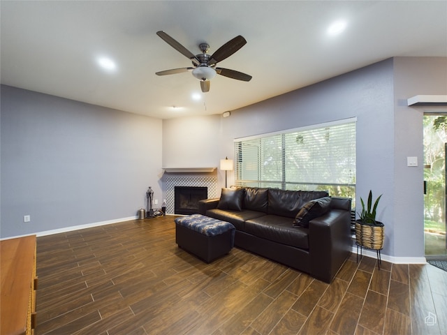 living room featuring dark hardwood / wood-style floors, a tiled fireplace, a wealth of natural light, and ceiling fan