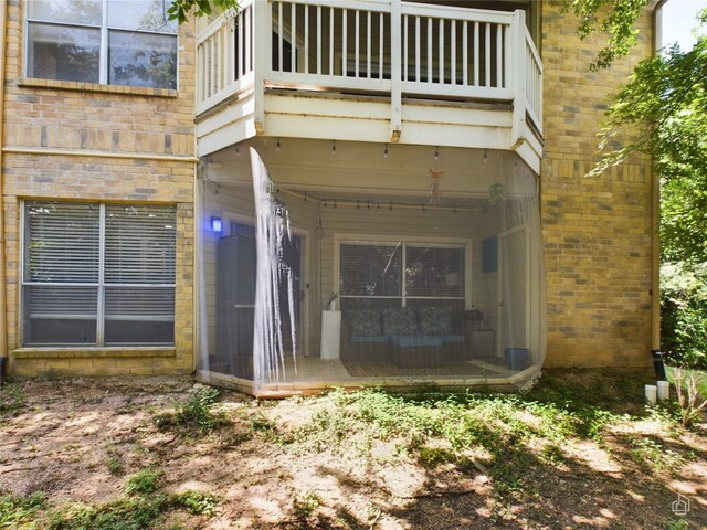 view of exterior entry featuring a balcony