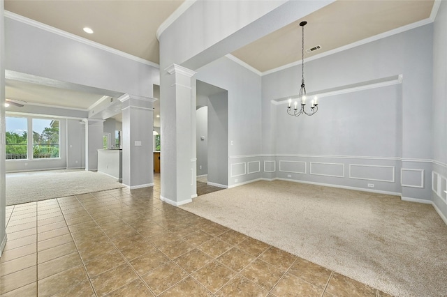 carpeted spare room featuring ornamental molding, ornate columns, and an inviting chandelier