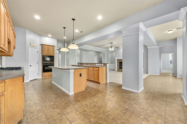 kitchen featuring light tile patterned floors, a kitchen island, ceiling fan, black appliances, and decorative light fixtures