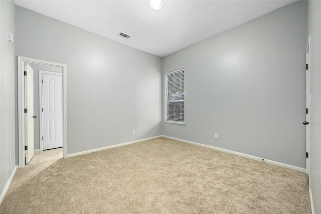 spare room featuring light carpet