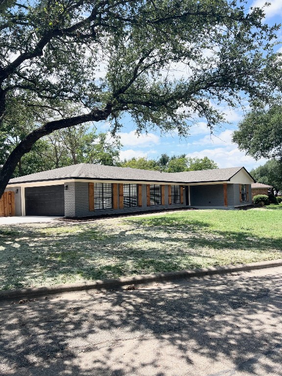 ranch-style house featuring a garage and a front yard