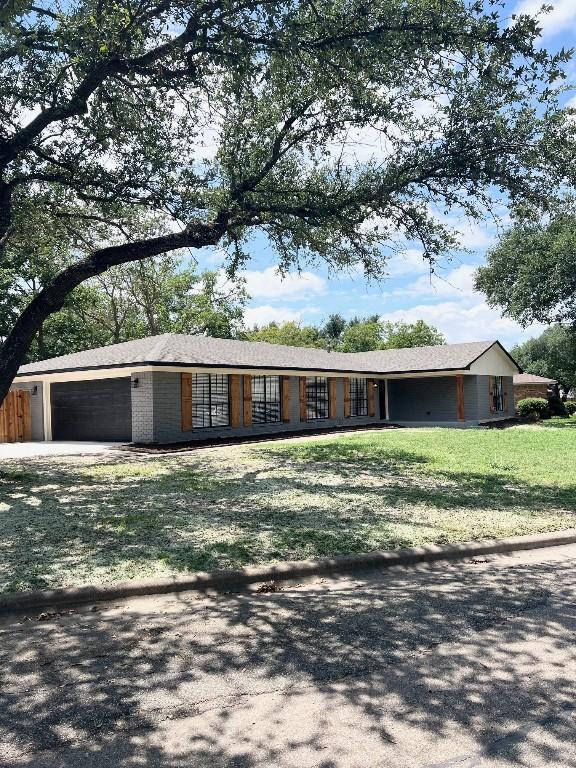 ranch-style home with a garage and a front yard